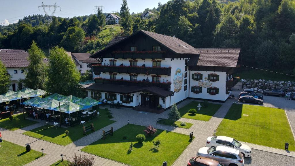 uma vista aérea de um grande edifício com carros estacionados num parque de estacionamento em Brandeberg Pension & Restaurant em Bran