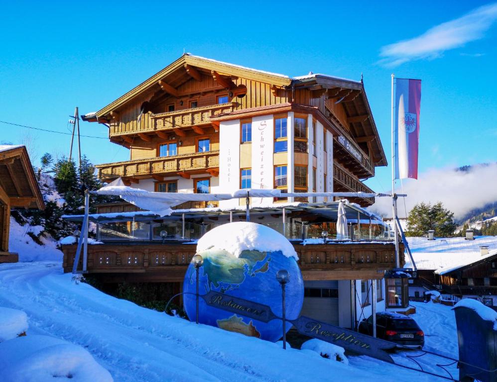 un edificio en la nieve con esquís delante en Hotel Schweizerhof, en Oberau