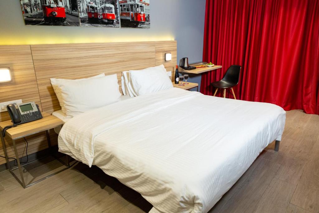 um quarto com uma cama grande e uma cortina vermelha em Caramel Boutique Hotel em Beirute