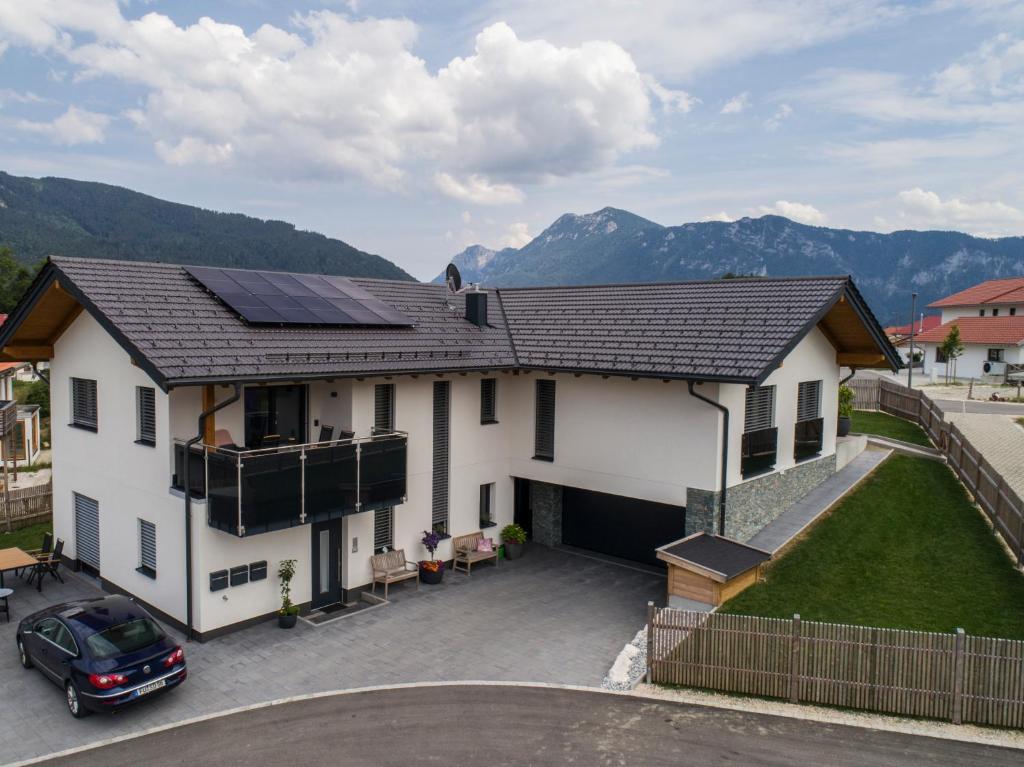 Casa blanca con paneles solares en el techo en Ferienwohnungen Mountainfloor - Chiemgau Karte, en Inzell