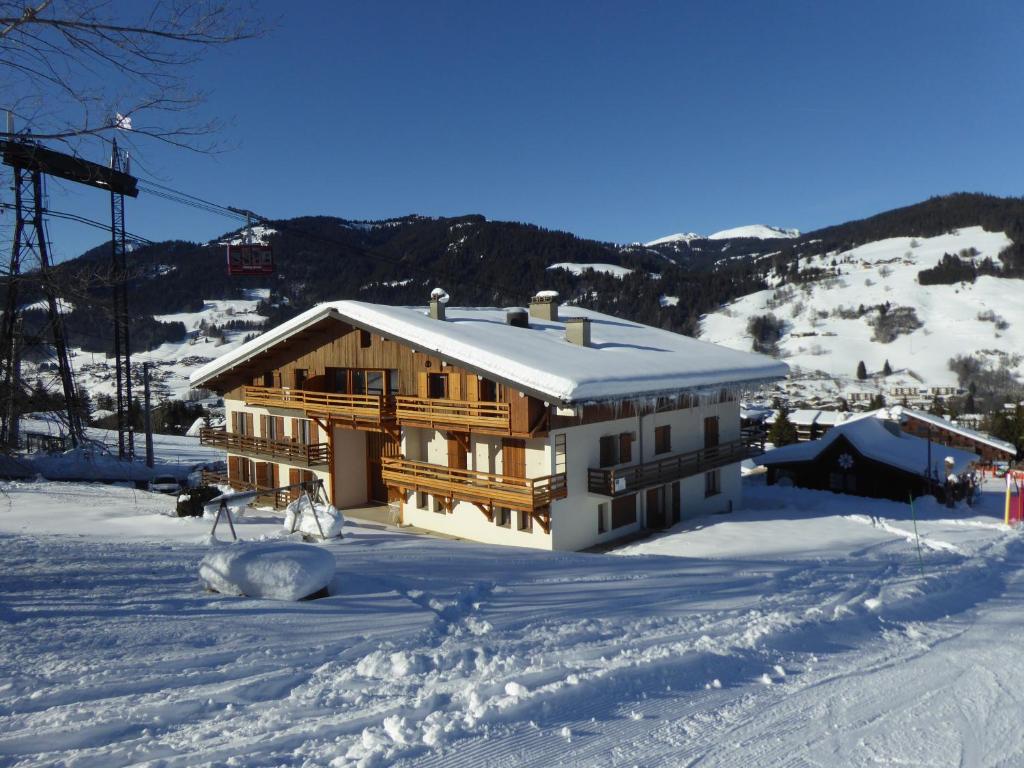 a house in the snow with a ski lift at Chalet Monte-Pente in Megève