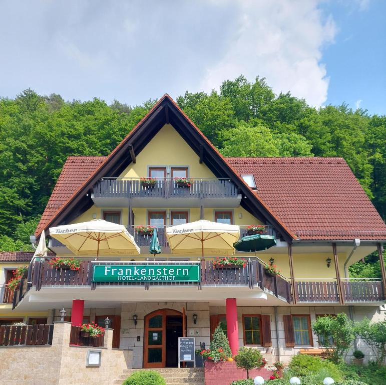 un edificio con ombrelloni di fronte di Hotel Landgasthof Frankenstern a Gössweinstein