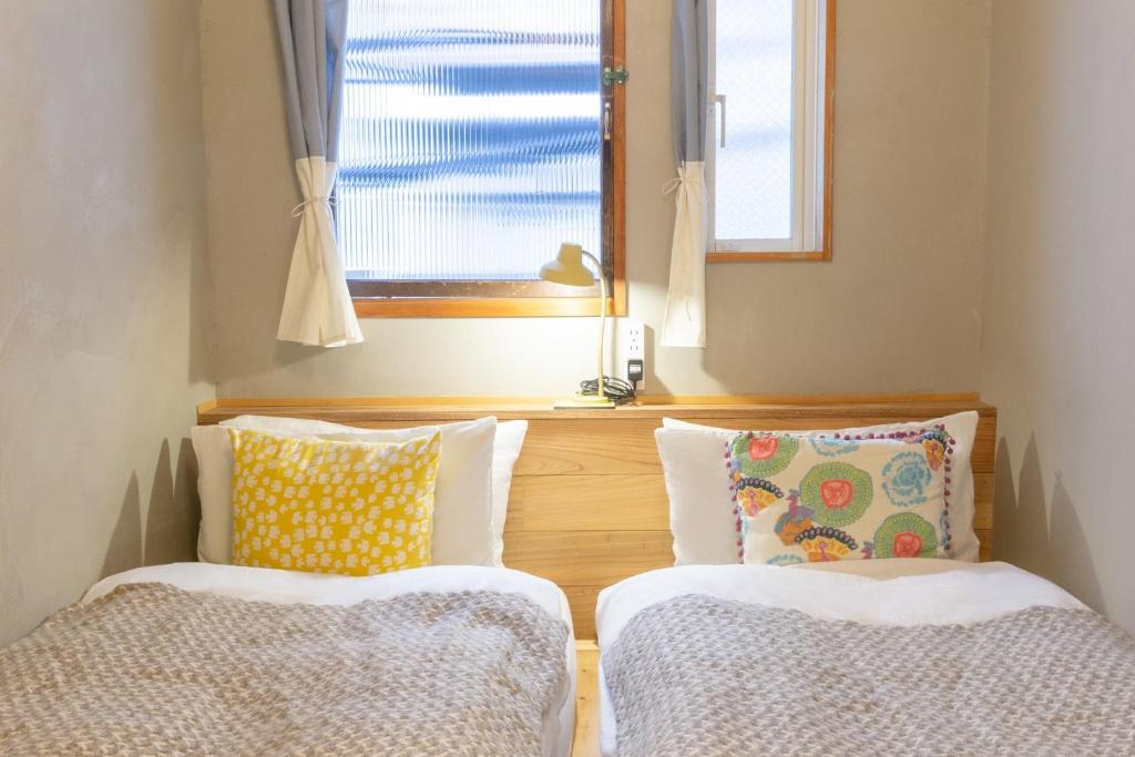 En eller flere senge i et værelse på Tokyo Hikari Guesthouse