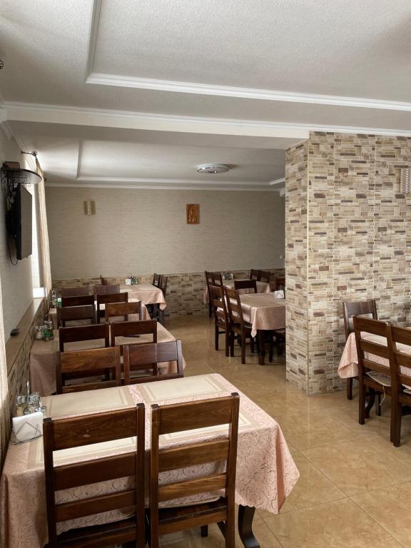 une salle à manger avec des tables et des chaises et un mur en briques dans l'établissement Горизонт, à Dragobrat