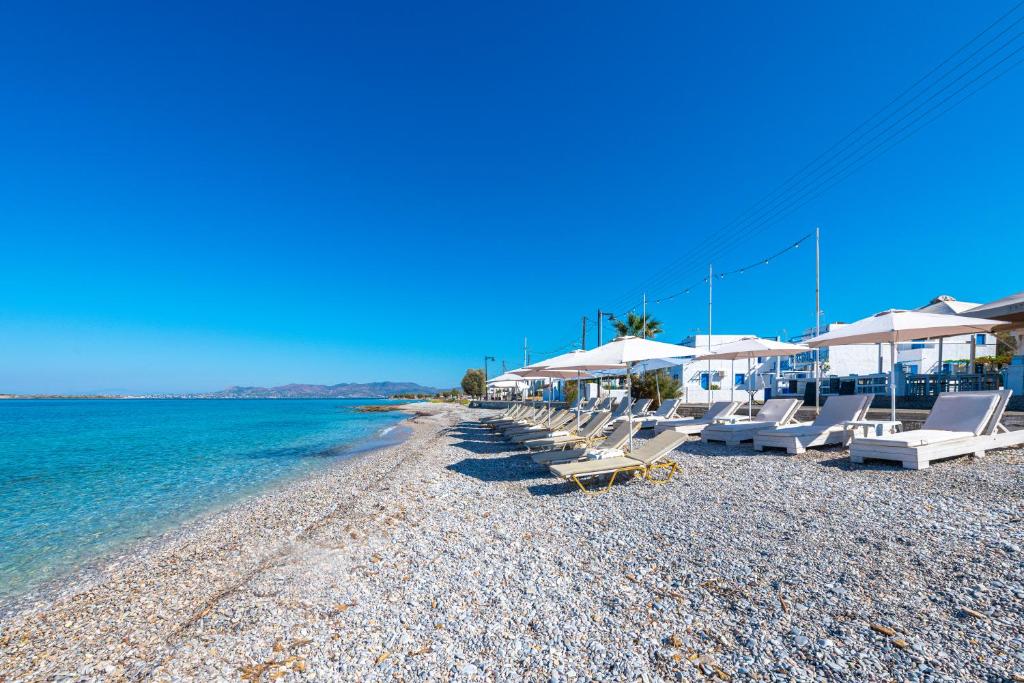 - une plage avec des chaises longues, des parasols et l'eau dans l'établissement Laza Beach, à Skala