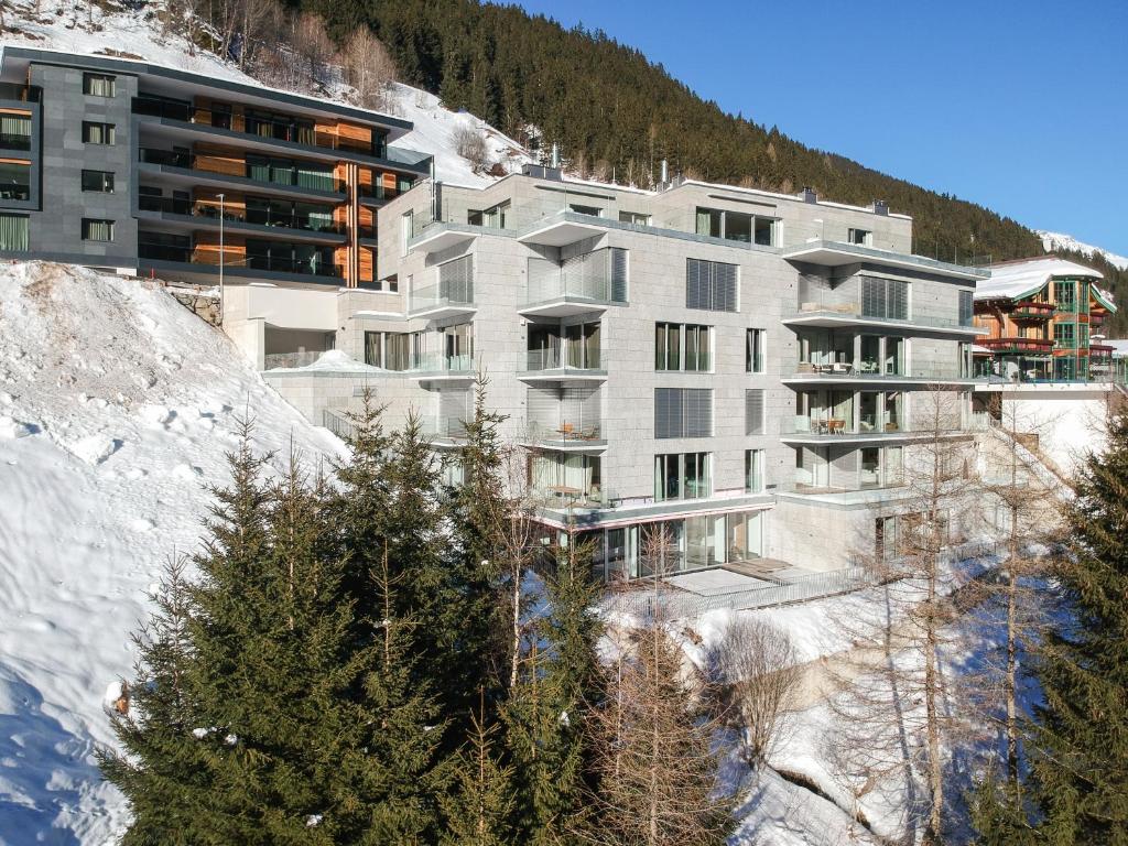 um edifício ao lado de uma montanha coberta de neve em Residenz Schooren des Alpes - Apartment SET - TOP 10 em Kappl