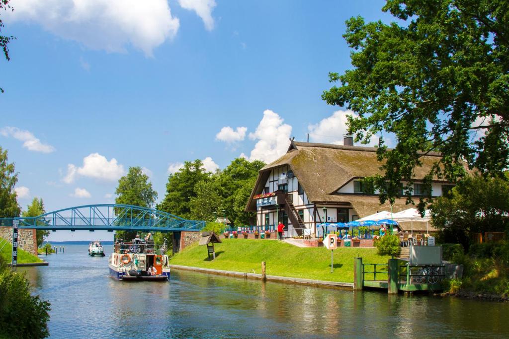 most nad rzeką z domem i łodzią w obiekcie Hotel & Restaurant Lenzer Krug w mieście Lenz