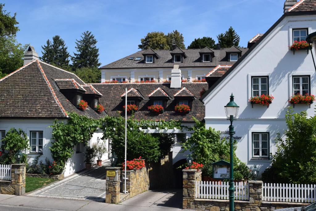 una casa blanca con flores en las ventanas en Hotel Landhaus Fuhrgassl-Huber, en Viena