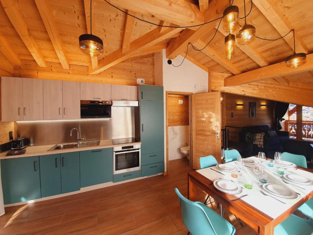 een keuken en eetkamer met een tafel en stoelen bij Chalet Delphinette - Spa privatif in Morzine