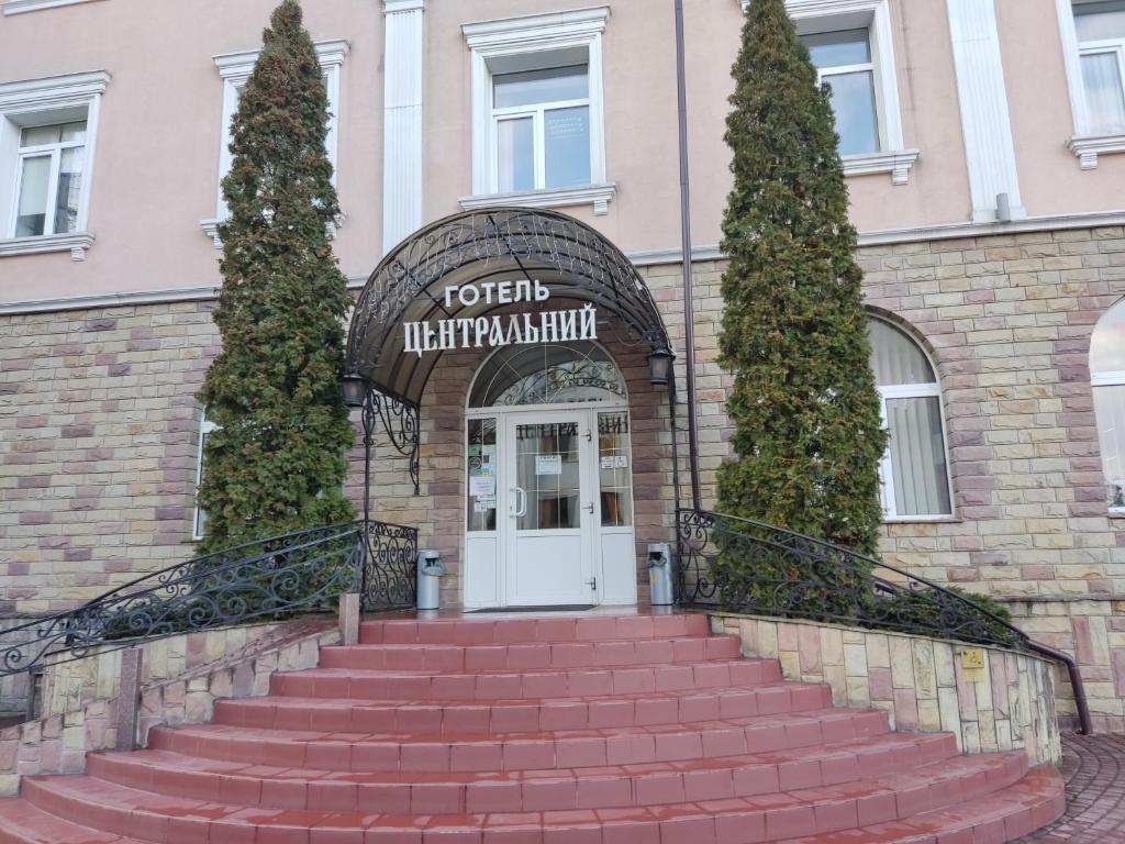 um conjunto de escadas que levam à porta da frente de um edifício em Tsentralniy Hotel em Khmelnytskyi