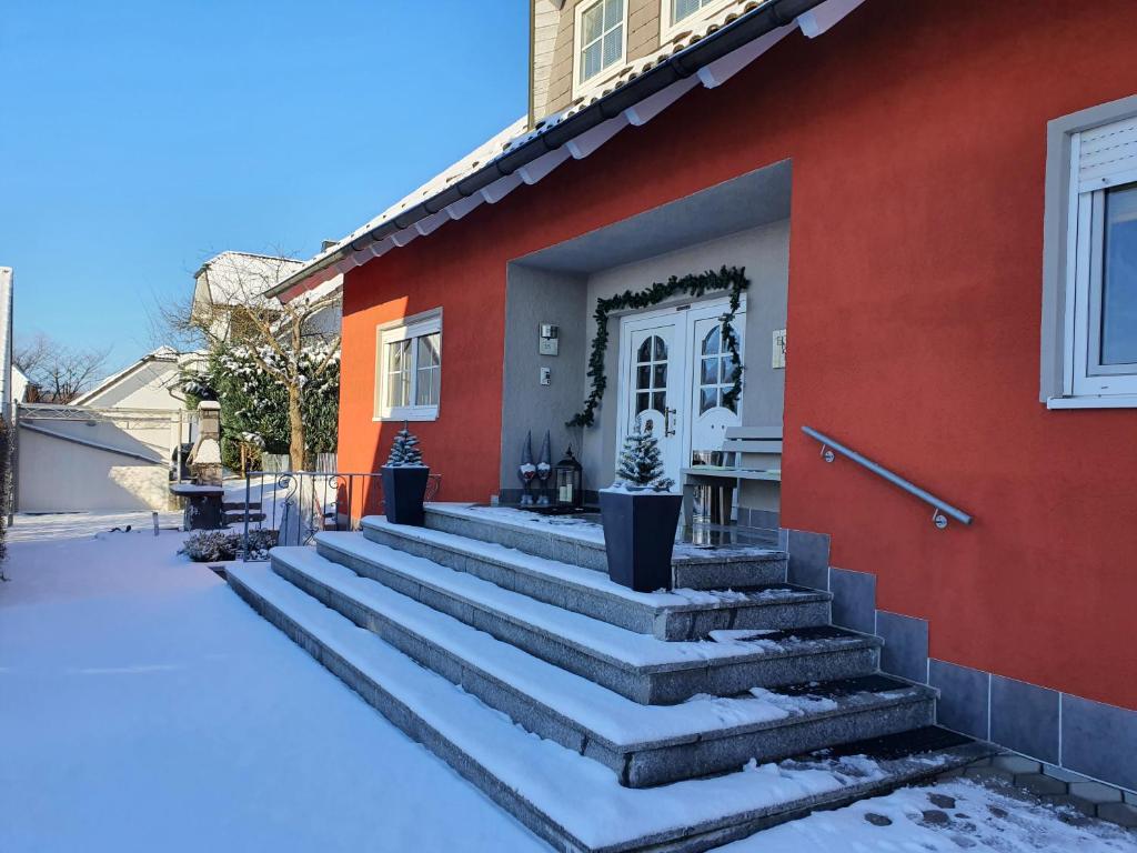 una casa rossa con le scale di fronte di Lindner Ferienwohnungen und Doppelzimmer a Fichtelberg