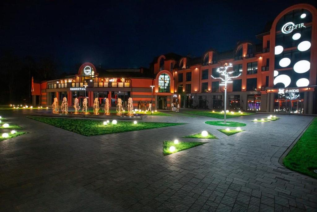 - un bâtiment avec des lumières dans une cour la nuit dans l'établissement Hotel Zefir, à Drogobych