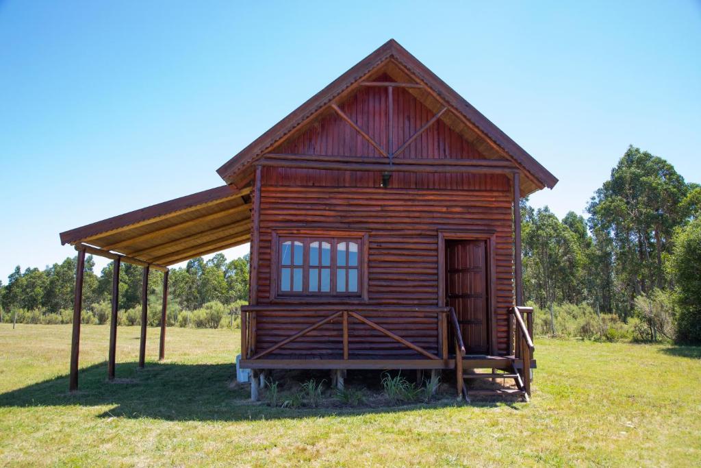 uma pequena cabana de madeira num campo de relva em Centro Los Alamos em Maldonado