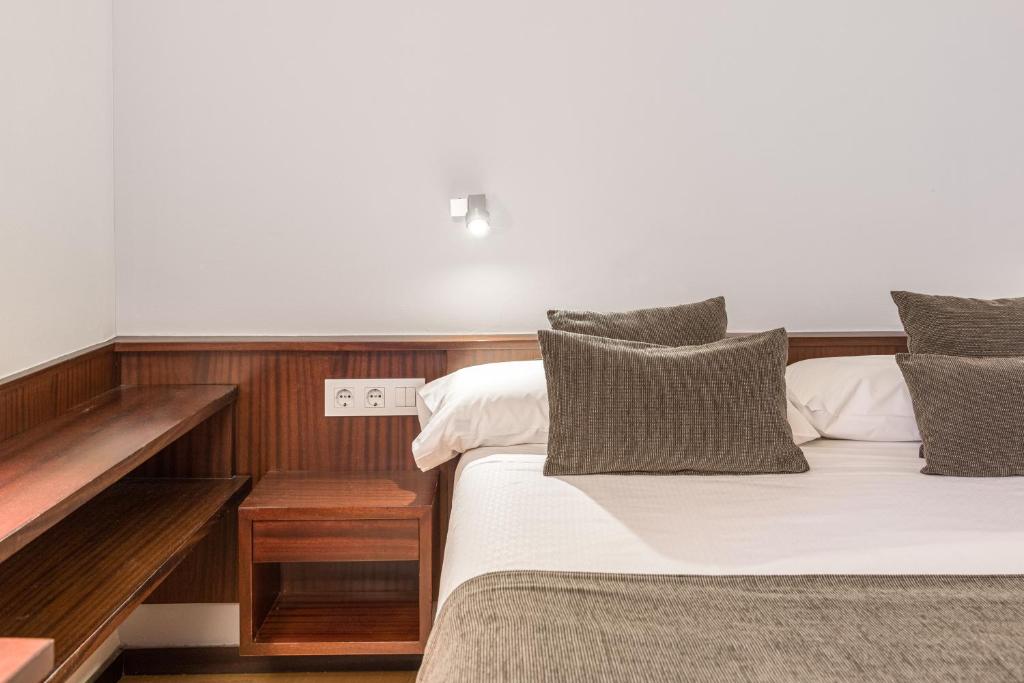 a bedroom with two beds and a wooden wall at Hotel Emporda in Figueres