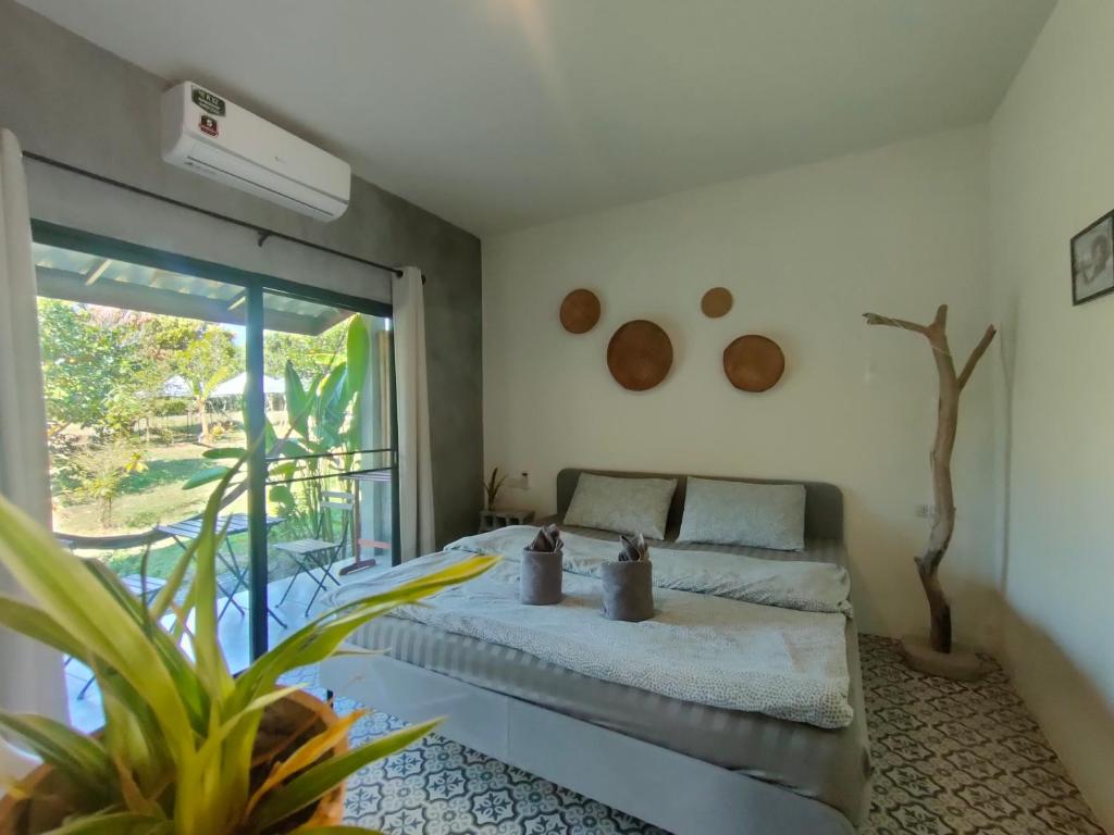 a bedroom with a bed and a large window at DOX Ko Lanta in Ko Lanta