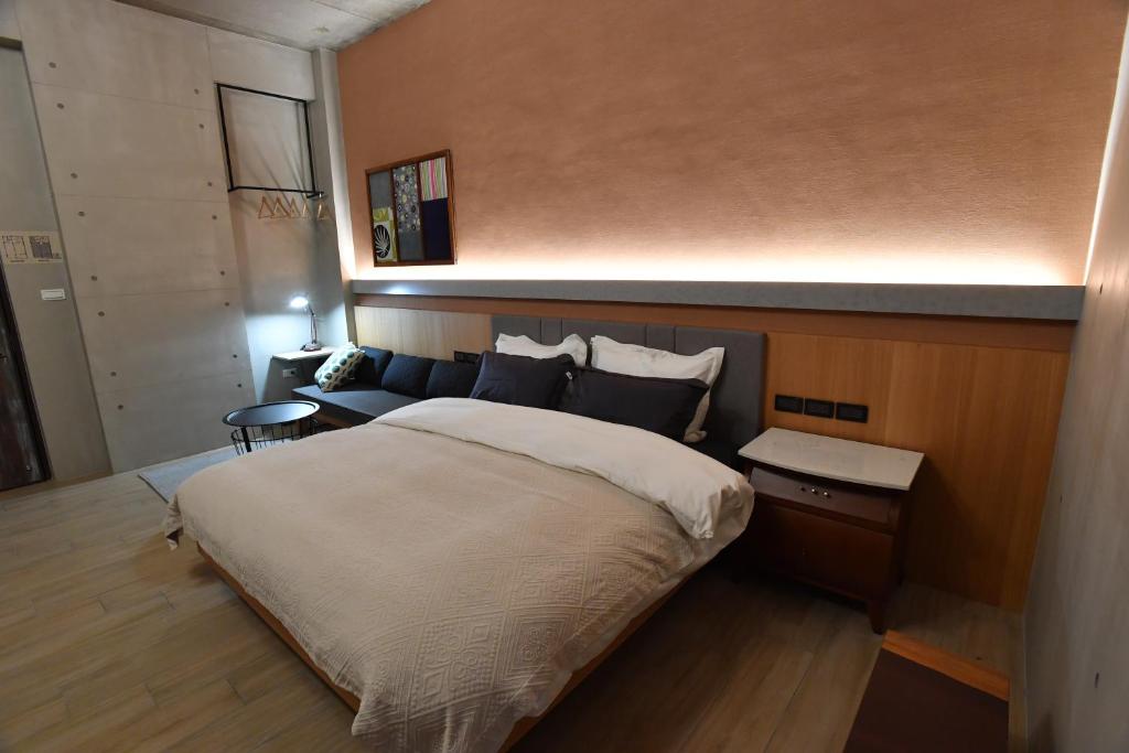 a bedroom with a large bed and a couch at Fu's house 52 in Tainan