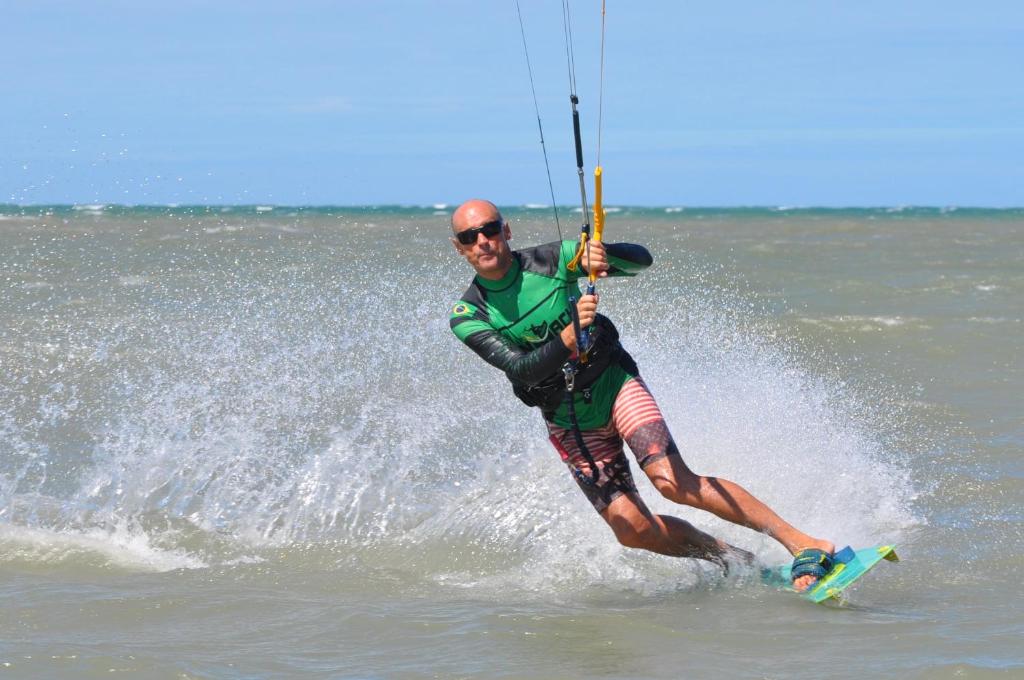 een man is waterskiën in de oceaan bij Pousada Casa Caju Bangalows in Cumbuco