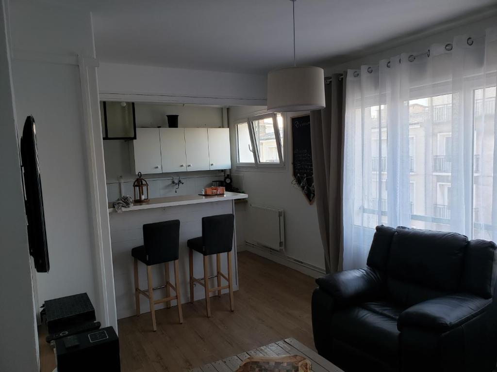 uma sala de estar com um sofá e uma cozinha em Bel appartement em Boulogne-sur-Mer