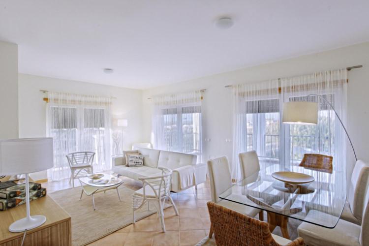 a living room with a glass table and chairs at Apartamentos Villa T2 Vila Sagres in Sagres