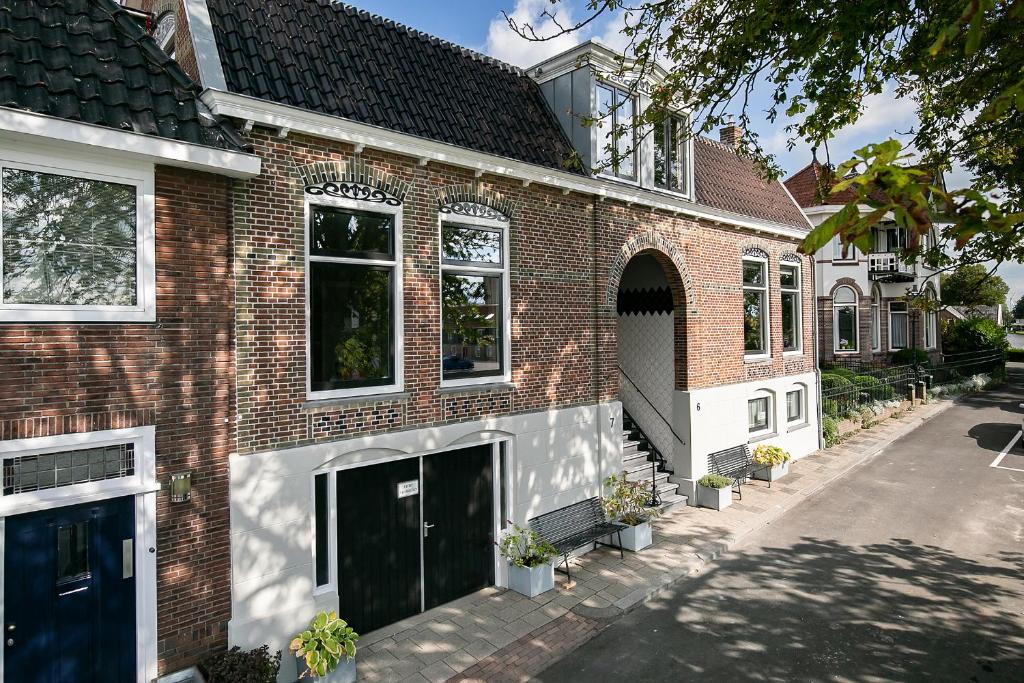 ein Backsteinhaus mit blauer Tür auf einer Straße in der Unterkunft Molepôlle 7 - Stadslogementen Franeker in Franeker