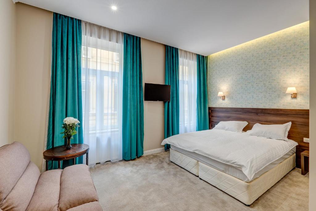 une chambre d'hôtel avec un lit et un canapé dans l'établissement Upstairs Boutique, à Bucarest