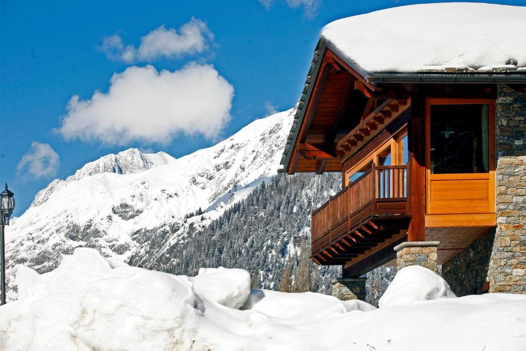 una cabaña en la nieve frente a una montaña en Les Combes, en La Salle