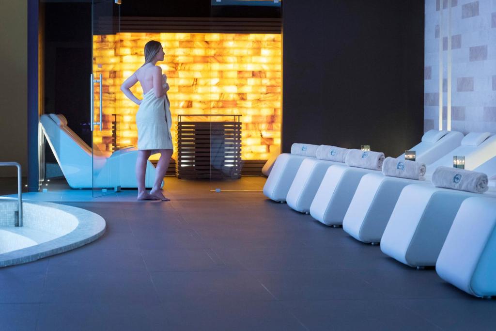 a woman standing in front of a room with white chairs at GHV Hotel in Vicenza