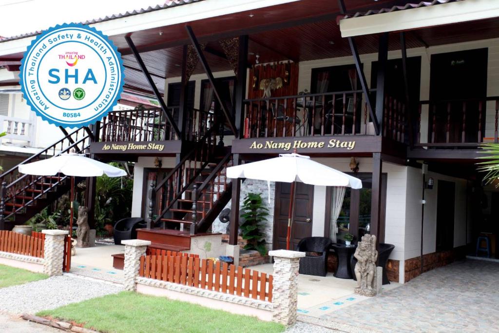 un restaurante con dos sombrillas frente a un edificio en Ao Nang Home Stay - Adults Only, en Ao Nang Beach