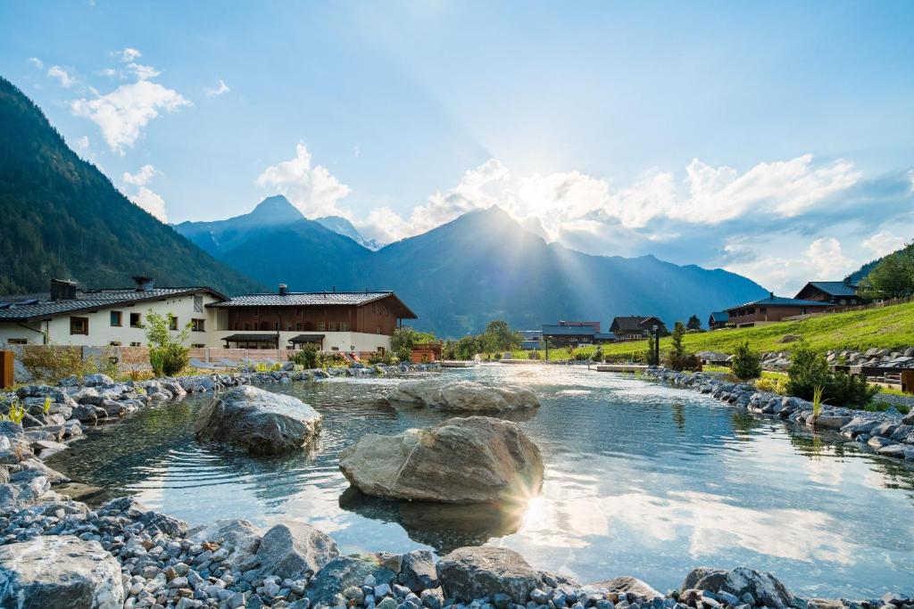 un río con rocas y montañas en el fondo en Hotel Gasthof Adler, en Sankt Gallenkirch