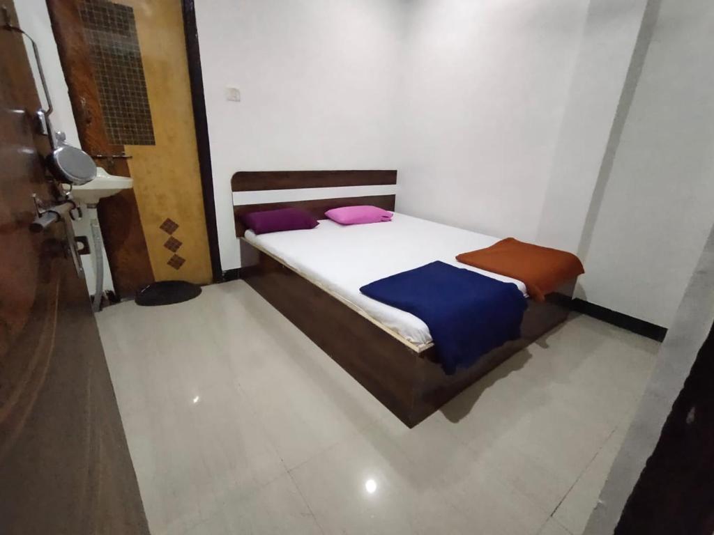 um pequeno quarto com uma cama num quarto em Sai Ganesh Guest House em Shirdi