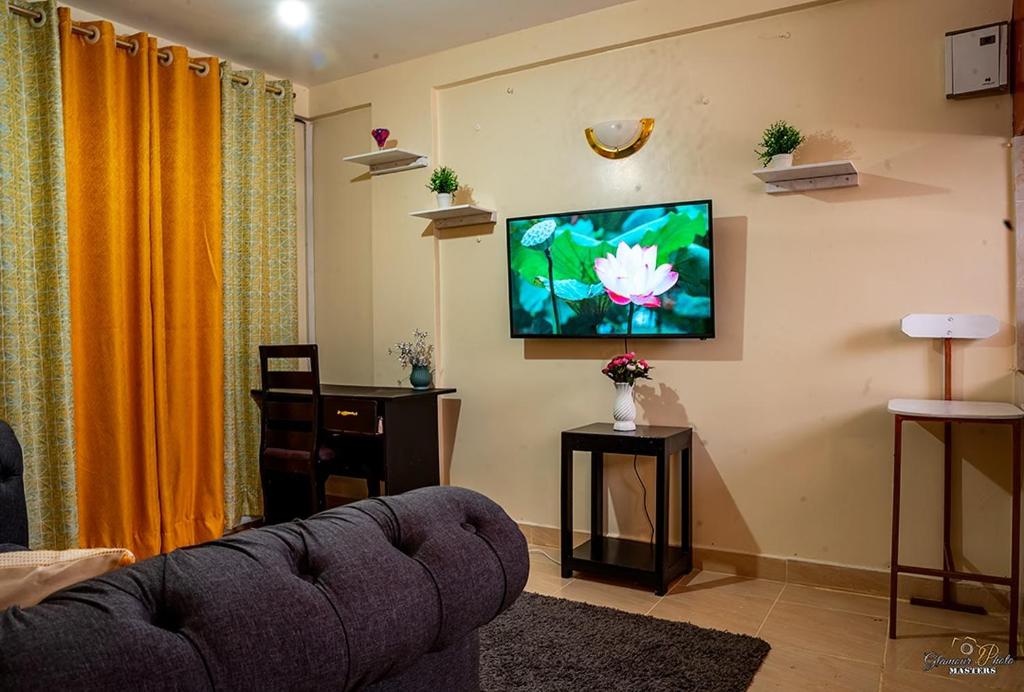 Una televisión o centro de entretenimiento en STYLISH 1BR APARTMENT IN KISUMU: FAST WI-FI, NETFLIX, SECURE PARKING