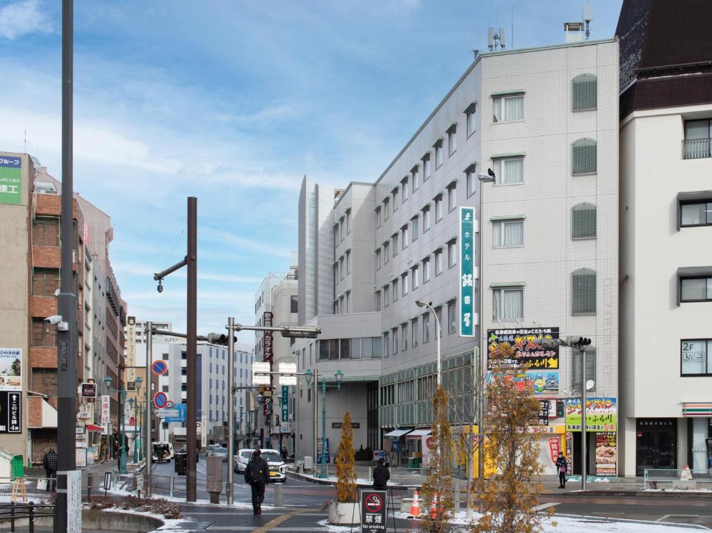 uma rua da cidade com um grande edifício branco em Hotel Iidaya em Matsumoto