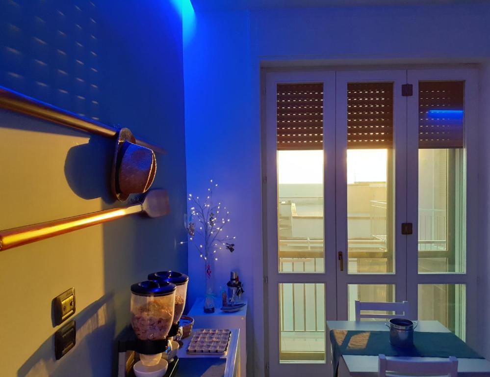 um quarto azul com uma porta, uma mesa e uma janela em Acquasalata em Salerno