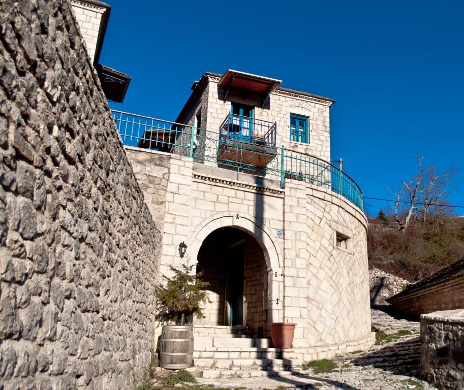 um edifício de pedra com uma varanda em cima em Napoleon Zaglis Guesthouse em Kalarrites