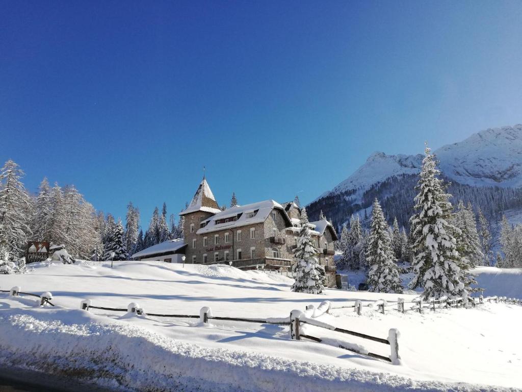 カレッツァ・アル・ラーゴにあるHotel Castel Latemarの雪中の大きな木々と山々