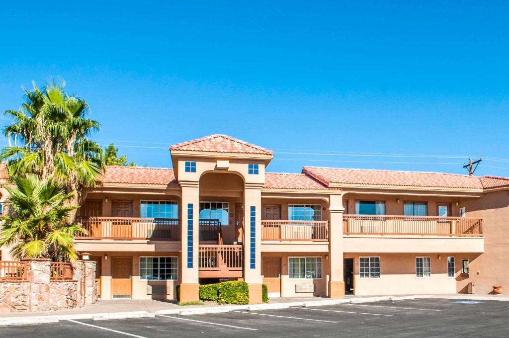 um grande edifício de apartamentos com uma palmeira em Quality Inn & Suites Las Cruces - University Area em Las Cruces