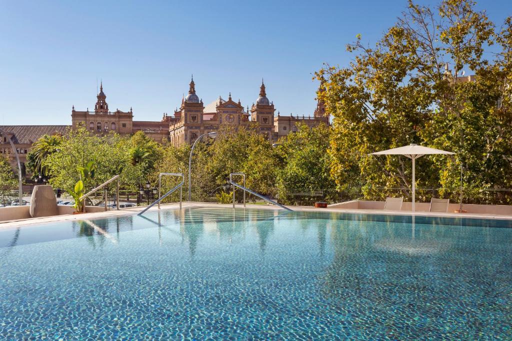 una grande piscina di fronte a un grande edificio di Melia Sevilla a Siviglia