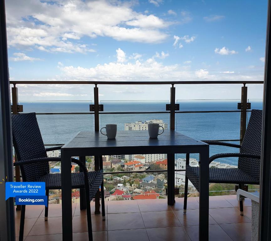 una mesa y sillas con vistas al océano en Level 24 - Sea & Sky View Apartment, en Odessa