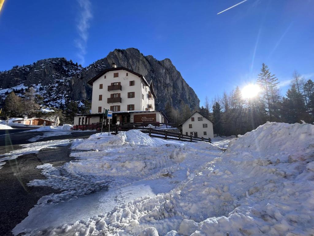 um grande edifício em frente a uma montanha com neve em Hotel Al Sasso di Stria em Andraz