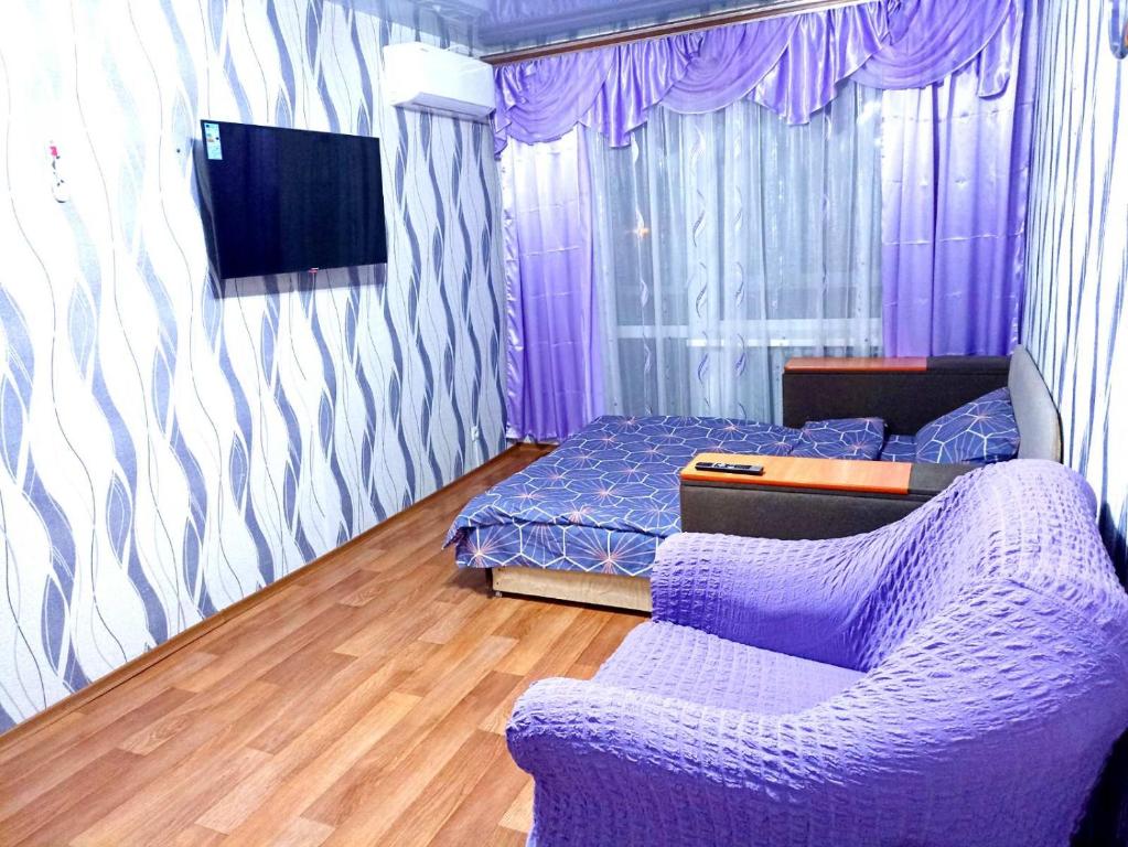 um quarto roxo com uma cama e um sofá em Уютные апартаменты c кондиционером на Уманчанке em Umanʼ