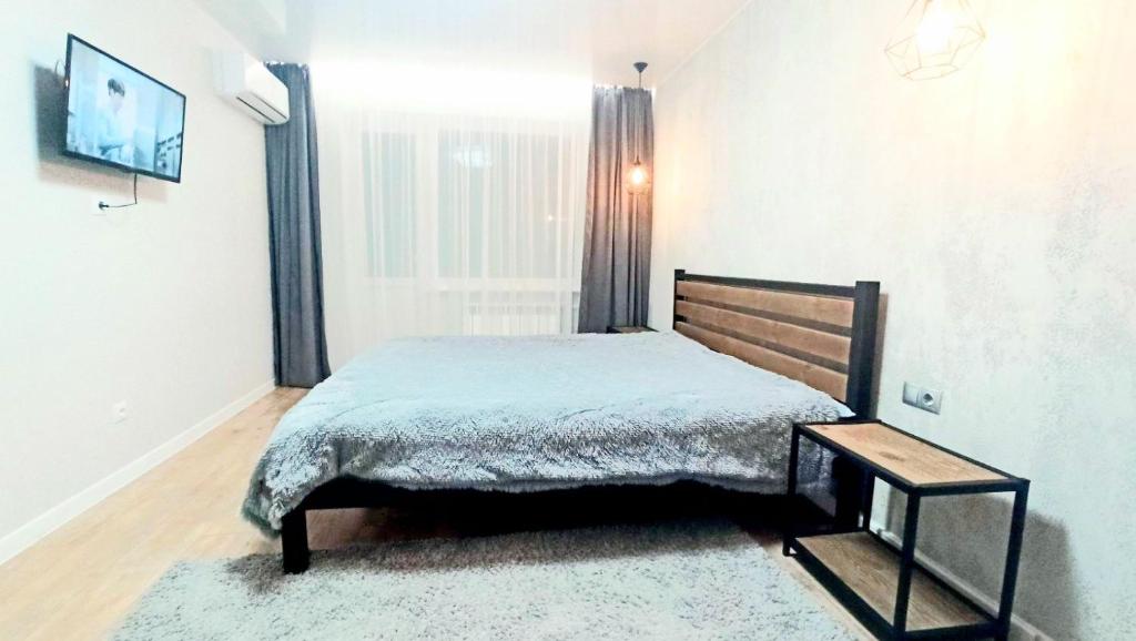 een slaapkamer met een bed en een groot raam bij Апартаменты улица Владимира Бызова in Krivoy Rog