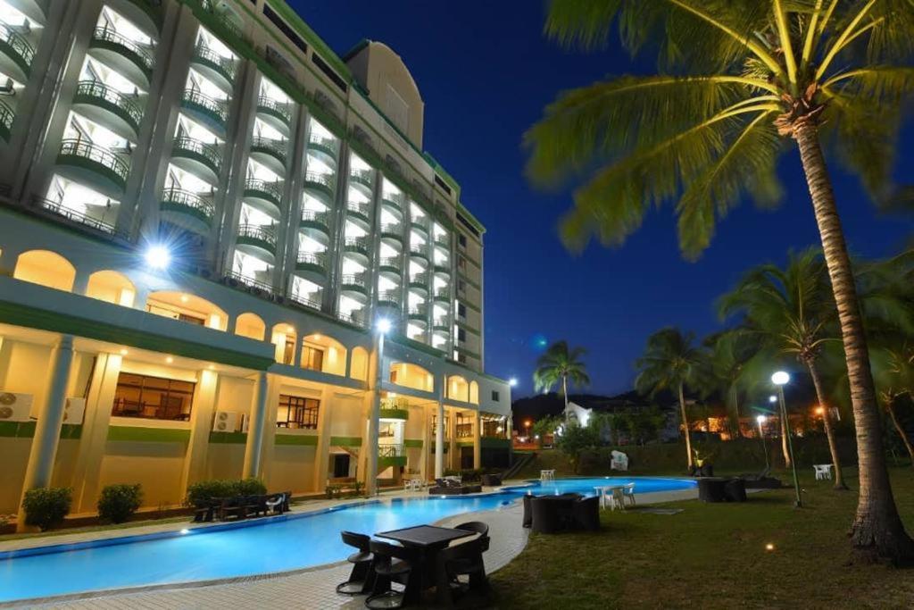 un hôtel avec une piscine en face d'un bâtiment dans l'établissement De Greenish Village Langkawi, à Kuah