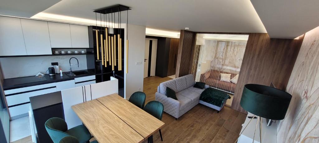 uma cozinha e sala de estar com mesa e cadeiras em Apartamenty IMPRESSA BASEN - SPA - SAUNA Lublin Centrum em Lublin