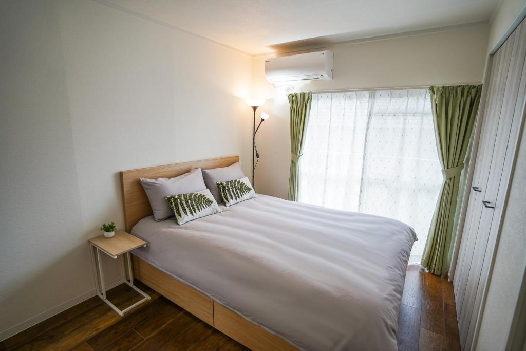 um quarto com uma grande cama branca e uma janela em stay's サンジョイフル 304号 名古屋 民泊 駅近 em Nagoya