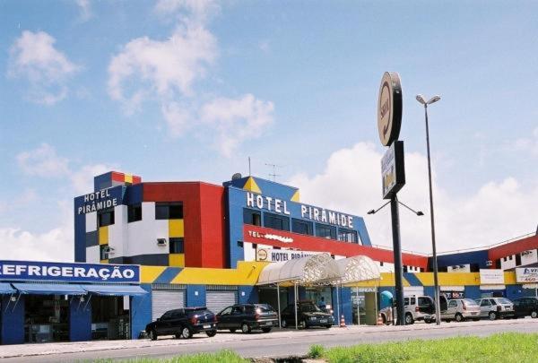 un parking de l'hôtel avec des voitures garées devant un bâtiment dans l'établissement Hotel Pirâmide Rodoviária, à Salvador