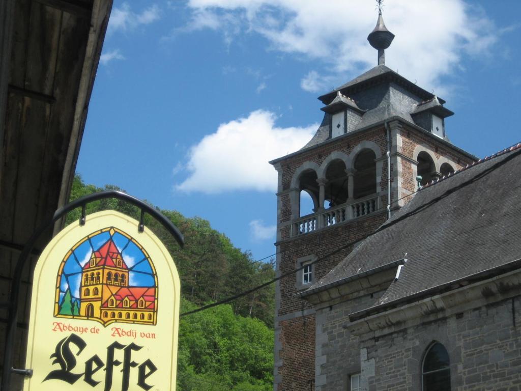 a sign on the side of a building with a tower at Claire de Meuse Cozy apartment Detox with river and hills in Anhée