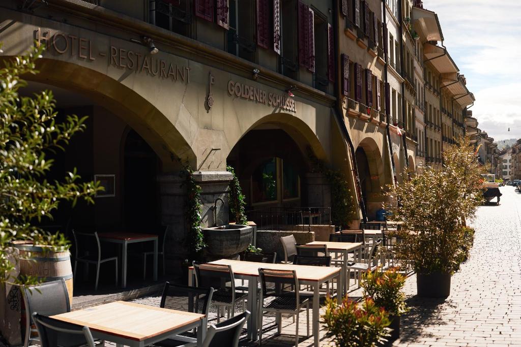 un groupe de tables et de chaises à l'extérieur d'un bâtiment dans l'établissement Goldener Schlüssel, à Berne