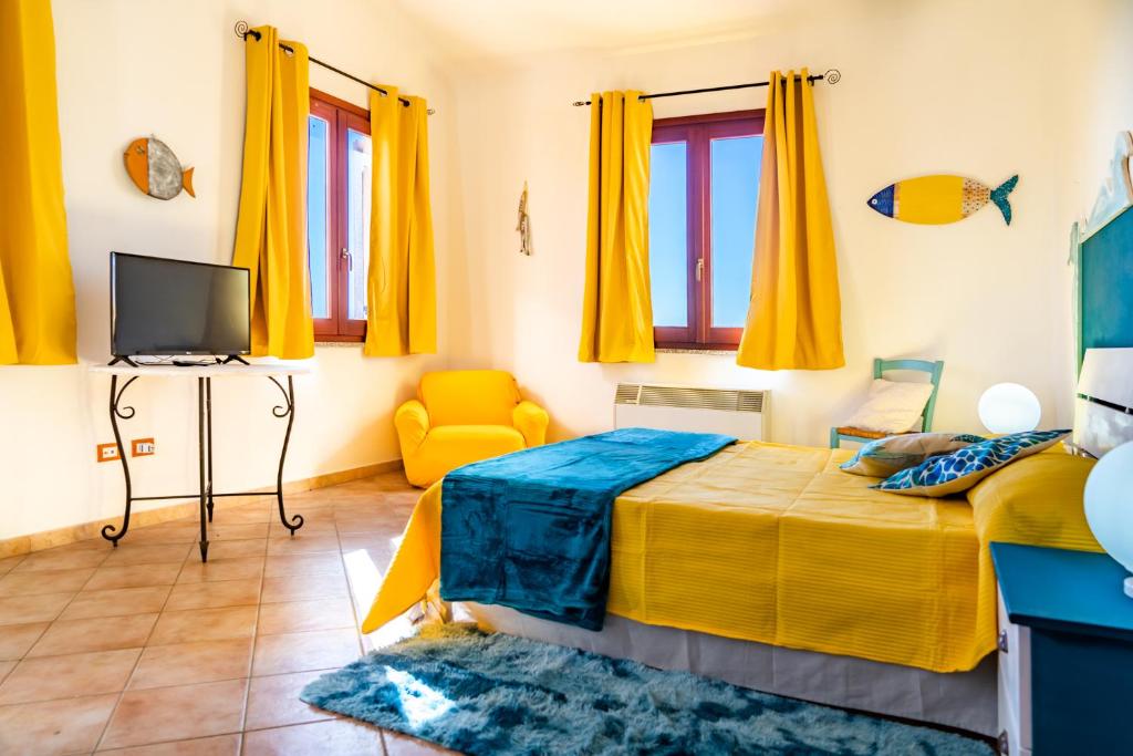 a bedroom with yellow curtains and a bed and a tv at Nora Guesthouse Rooms and Villas in Pula