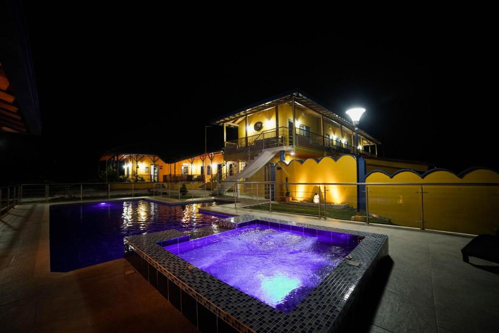 un edificio con piscina di notte di Ecohotel Guaduales Pereira a Pereira