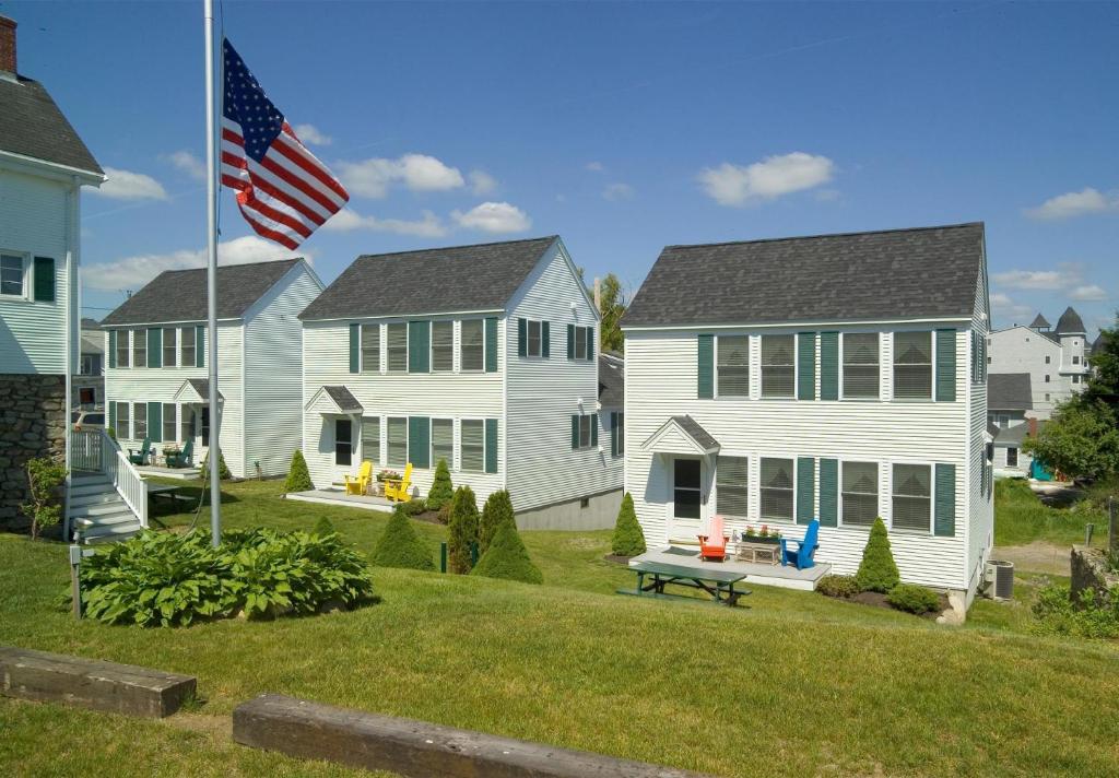 een rij huizen met een Amerikaanse vlag bij Owls Head Cottage at One Long Beach in York Beach